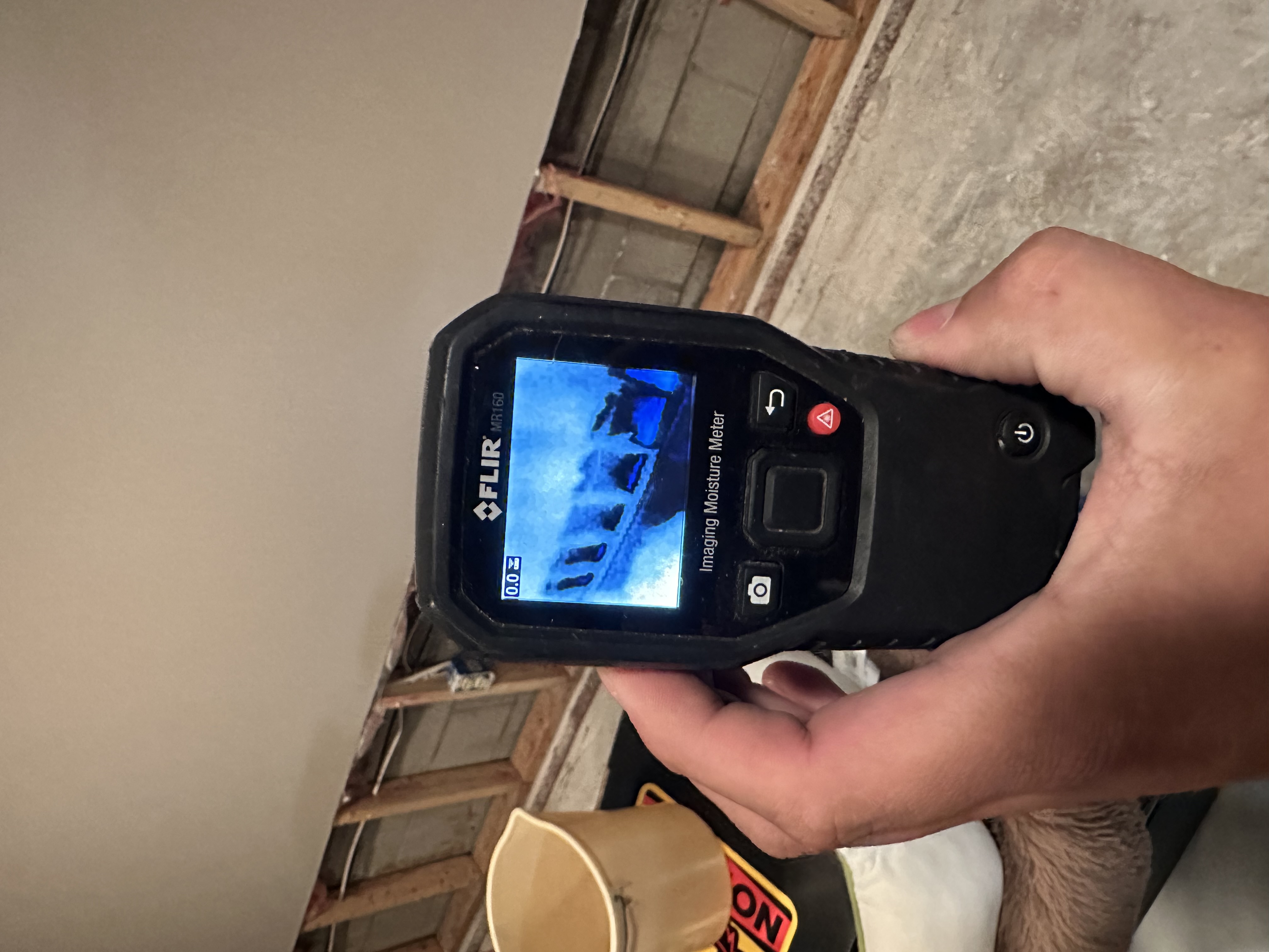 FLIR MR160 moisture meter displaying thermal imaging of wall framing and moisture detection during professional water damage assessment