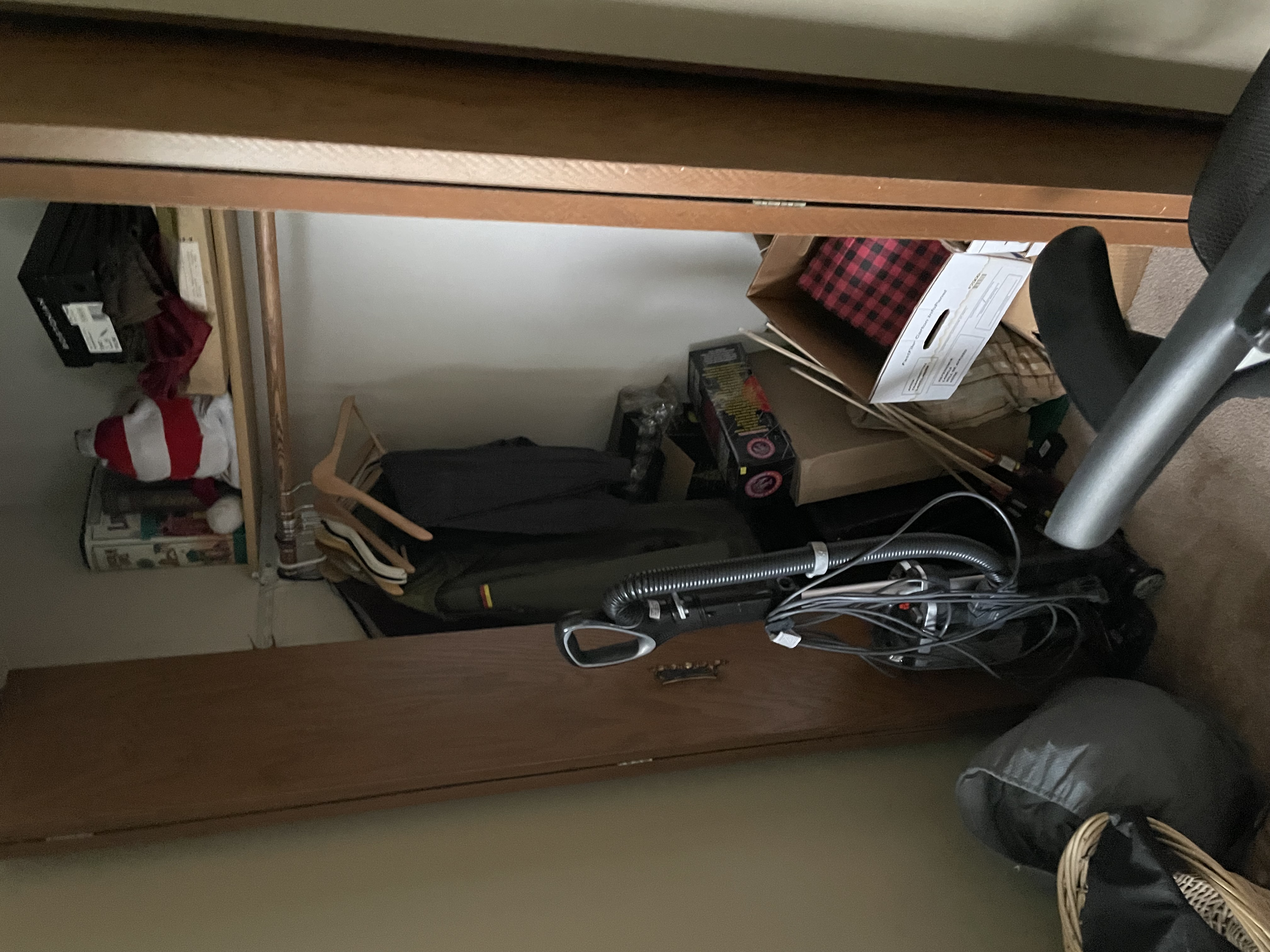 Bedroom closet with water damage restoration equipment including vacuum system with hoses and personal belongings moved for protection during restoration work