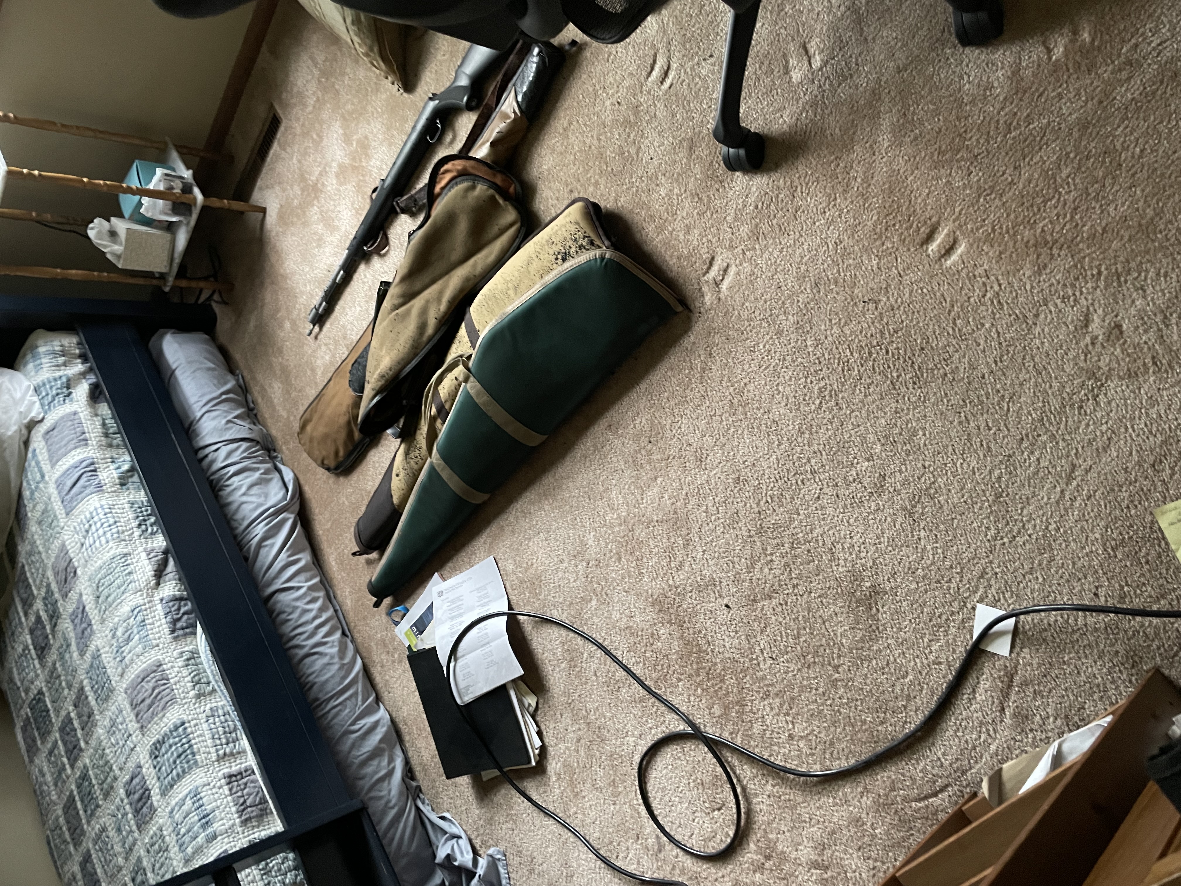 Bedroom with water damage restoration equipment including air movers positioned on carpet with personal belongings and luggage scattered during restoration process