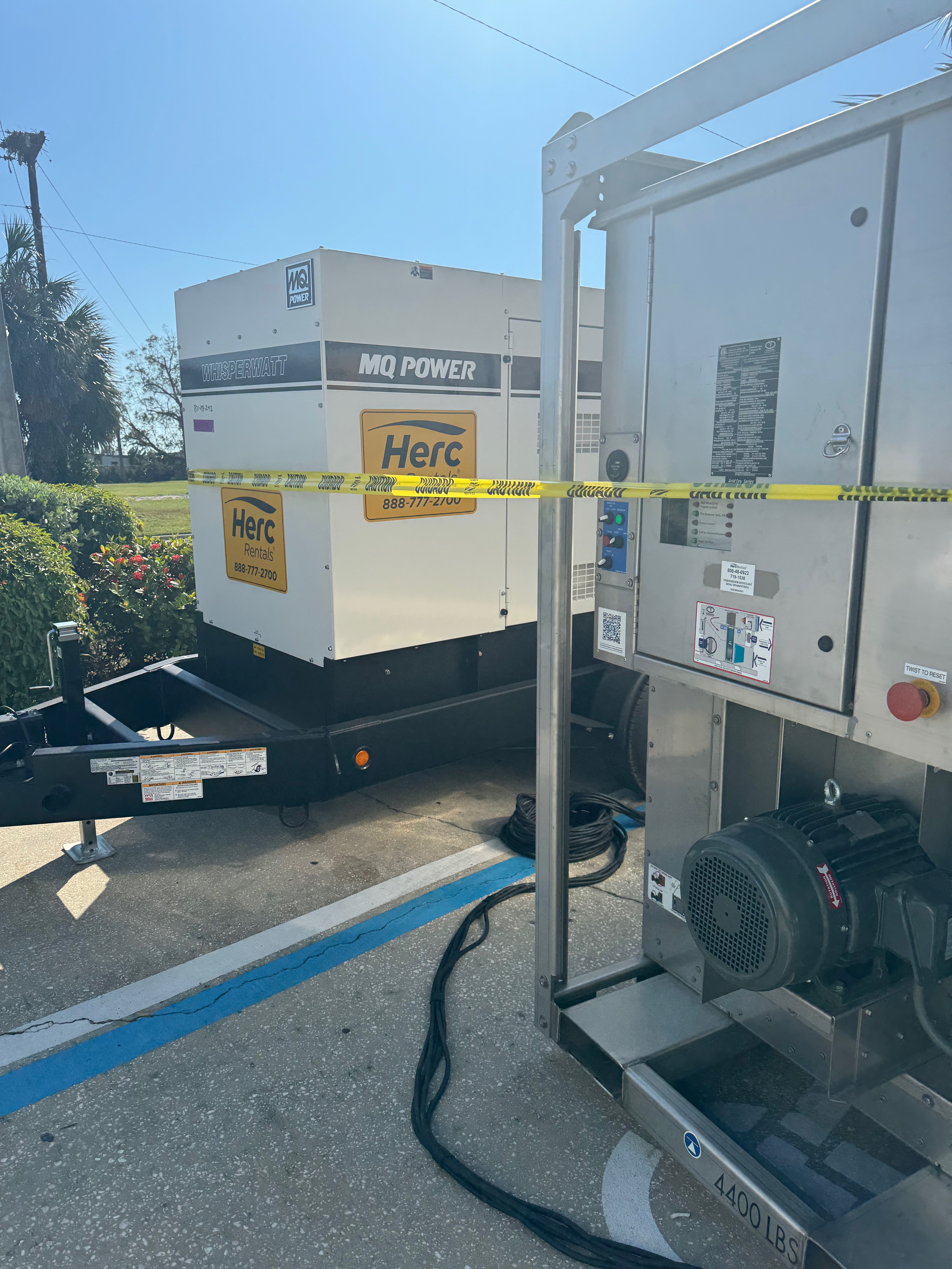MQ POWER generator and HercRentals water damage restoration equipment with yellow caution tape at Plymouth emergency job site